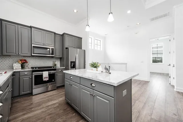 a kitchen with stainless steel appliances granite countertop a sink stove and refrigerator
