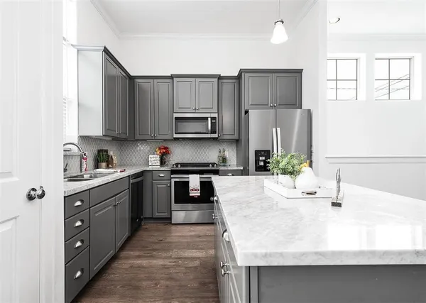 a kitchen with kitchen island granite countertop a sink stove and refrigerator