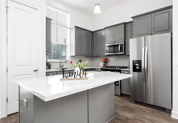 a kitchen with a refrigerator a sink a stove a microwave and cabinets
