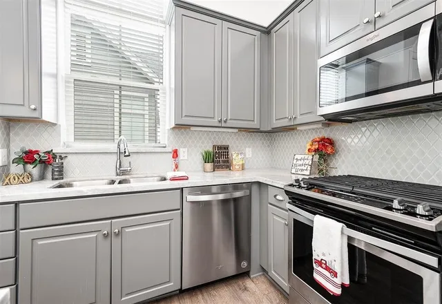 a kitchen with stainless steel appliances granite countertop a sink and a stove