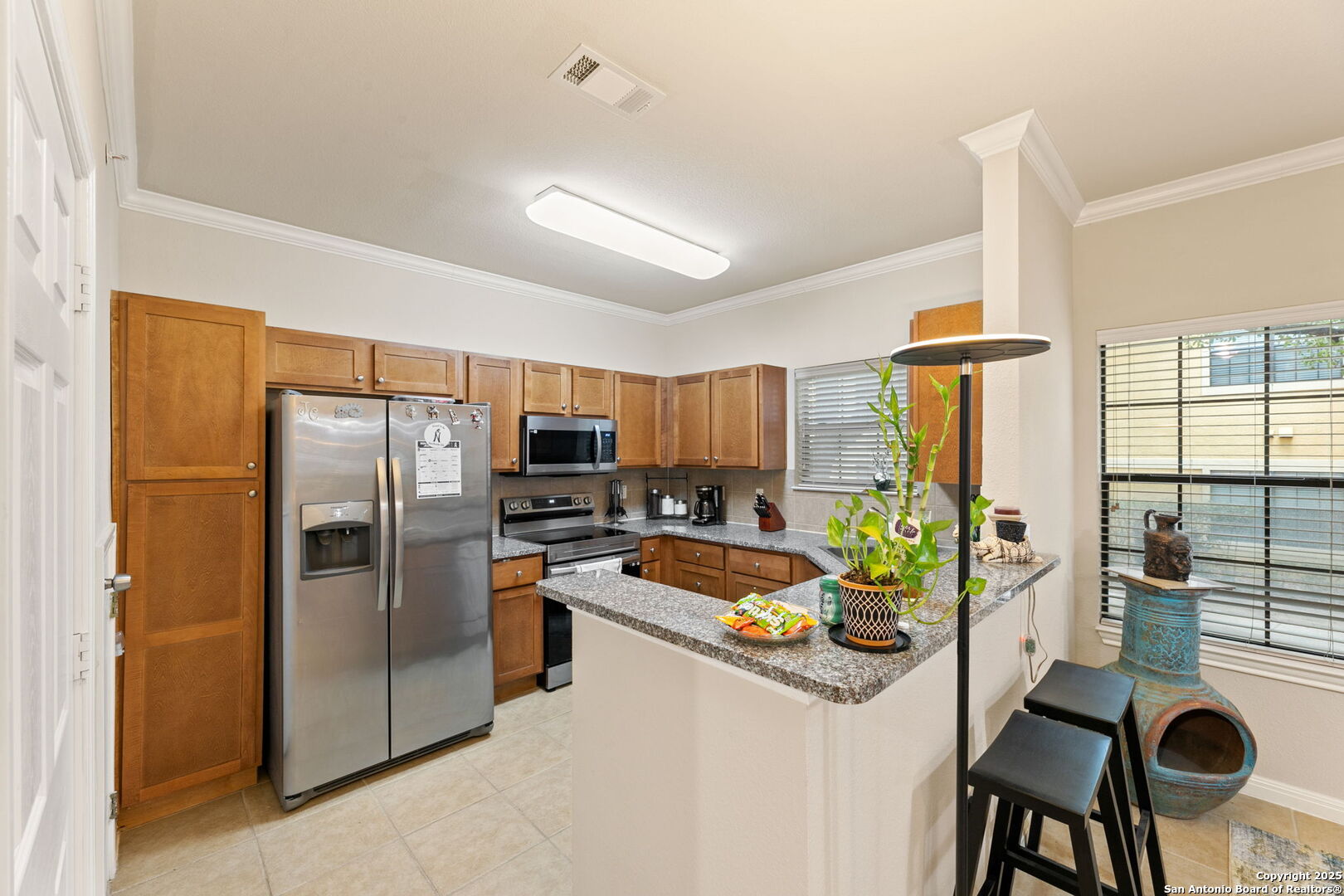6160 Eckhert Road, Unit 204 San Antonio, TX 78240 - Photo 11 of 30 a kitchen with stainless steel appliances granite countertop a refrigerator a stove a sink dishwasher with a dining table and chairs