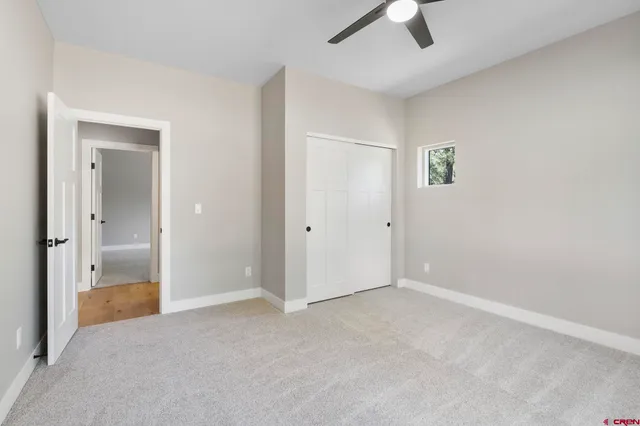 an empty room with fan and windows