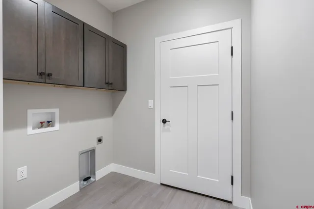 a view of an empty room with wooden floor and cabinets