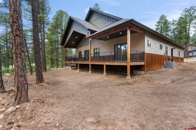 a view of a house with a yard and wooden fence