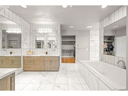 a large bathroom with a tub a sink a mirror and a shower