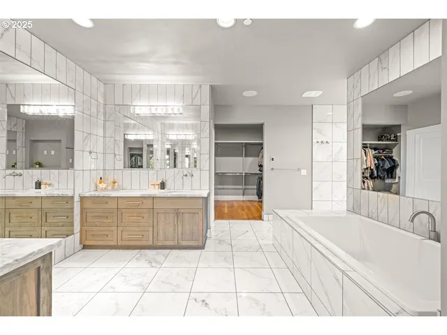 a large bathroom with a tub a sink a mirror and a shower