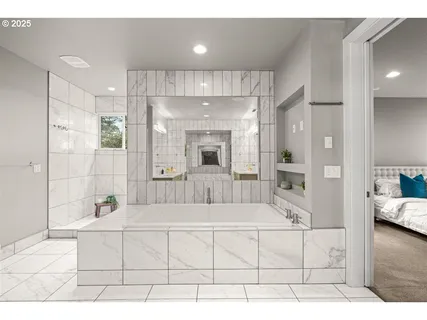 a bathroom with a tub a double vanity sink and mirrors