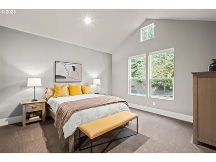 a bedroom with a bed a window and a lamp