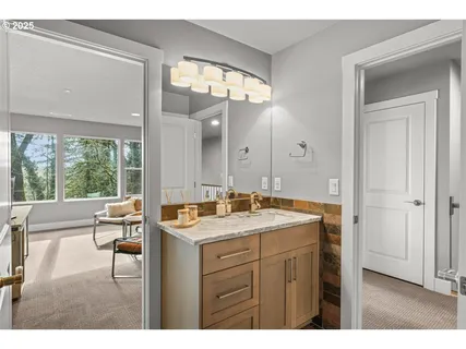 a bathroom with a sink vanity granite tub and a mirror