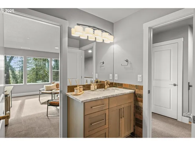 a bathroom with a sink vanity granite tub and a mirror
