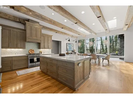 a large kitchen with stainless steel appliances granite countertop a large stove a sink dishwasher and cabinets with wooden floor