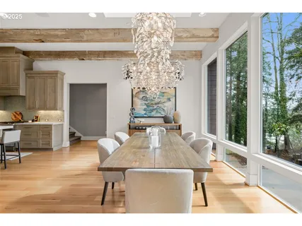 a living room with furniture a large window and wooden floor