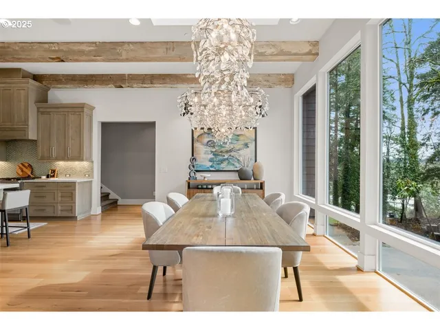 a living room with furniture a large window and wooden floor