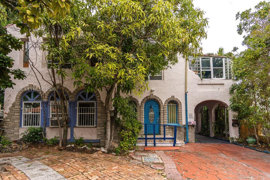 2345 Southwest 19th Street Miami, FL 33145 - Photo 1 of 21 a view of a white house with a tree and many windows