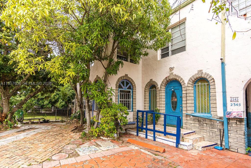 2345 Southwest 19th Street Miami, FL 33145 - Photo 13 of 21 a view of a house with brick walls plants and large tree
