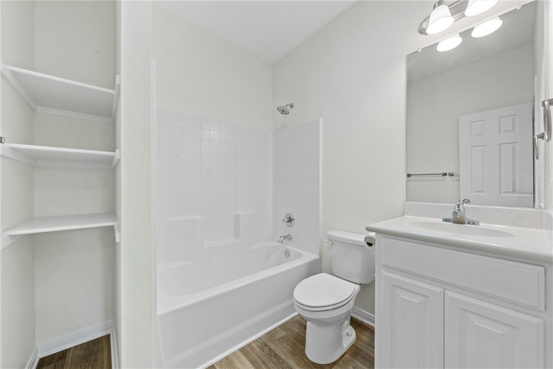 1325 North 11th Street Waco, TX 76707 - Photo 20 of 24 a bathroom with a toilet a sink a mirror and bathtub