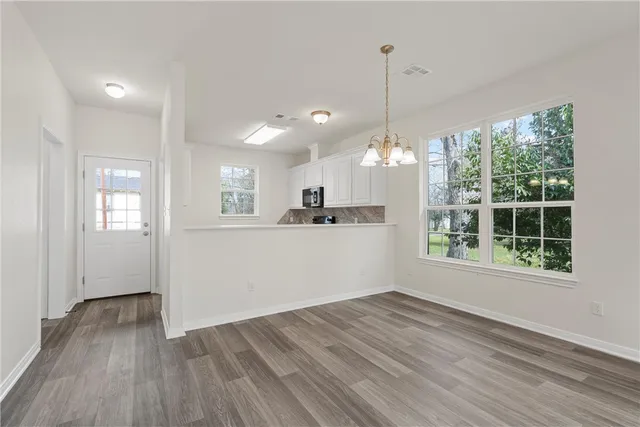 a view of a kitchen with wooden floor and windows