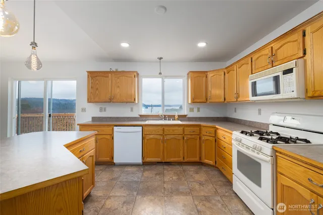 a kitchen with stainless steel appliances granite countertop a stove a sink and a microwave