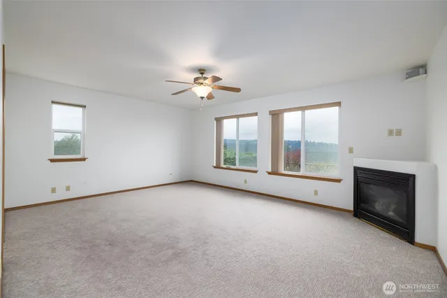 a view of an empty room with a fireplace and a window