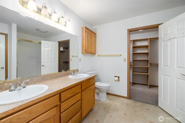 a bathroom with a granite countertop sink mirror and toilet