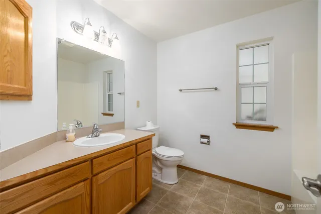 a bathroom with a double vanity sink mirror and toilet
