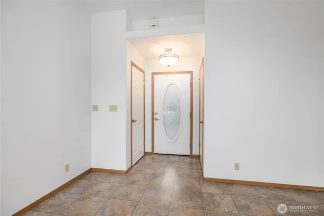 a view of an empty room with closet and mirror