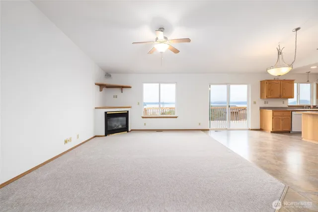 an empty room with windows and fireplace