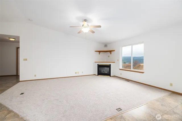 an empty room with windows and fireplace