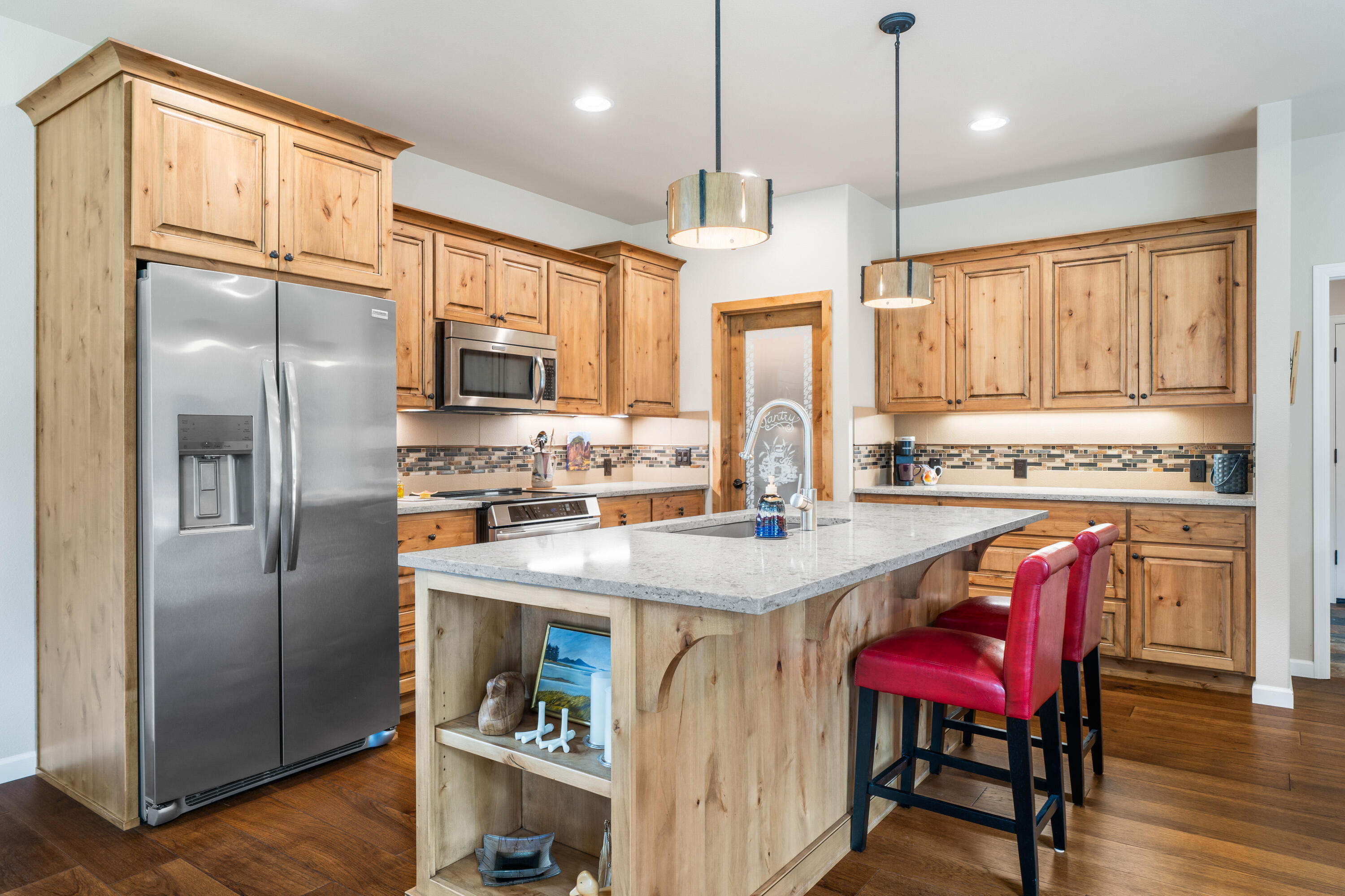 205 Vista Rim Drive Redmond, OR 97756 - Photo 10 of 85 a kitchen with stainless steel appliances granite countertop a refrigerator a sink dishwasher a stove and a refrigerator with wooden floor