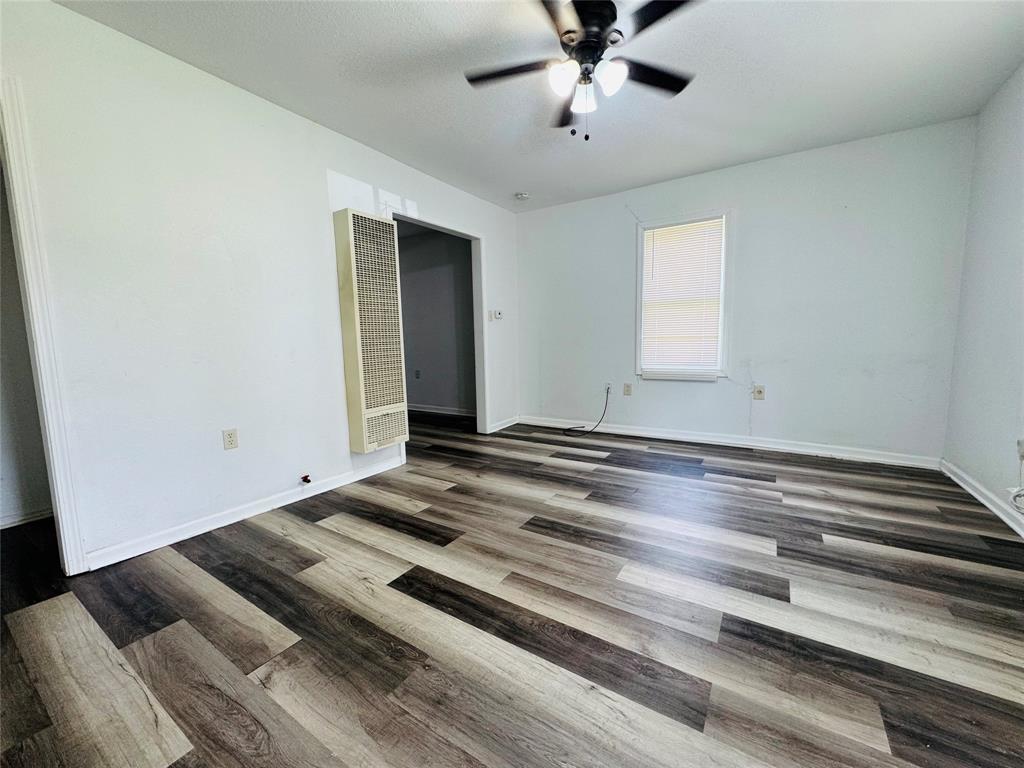 4393 Old Dallas Road Elm Mott, TX 76640 - Photo 3 of 19 Unfurnished bedroom featuring a heating unit, wood finished floors, and ceiling fan