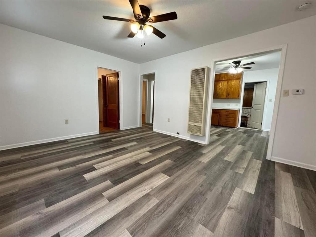 4393 Old Dallas Road Elm Mott, TX 76640 - Photo 4 of 19 Unfurnished bedroom with a heating unit, dark wood-type flooring, a ceiling fan, and ensuite bathroom