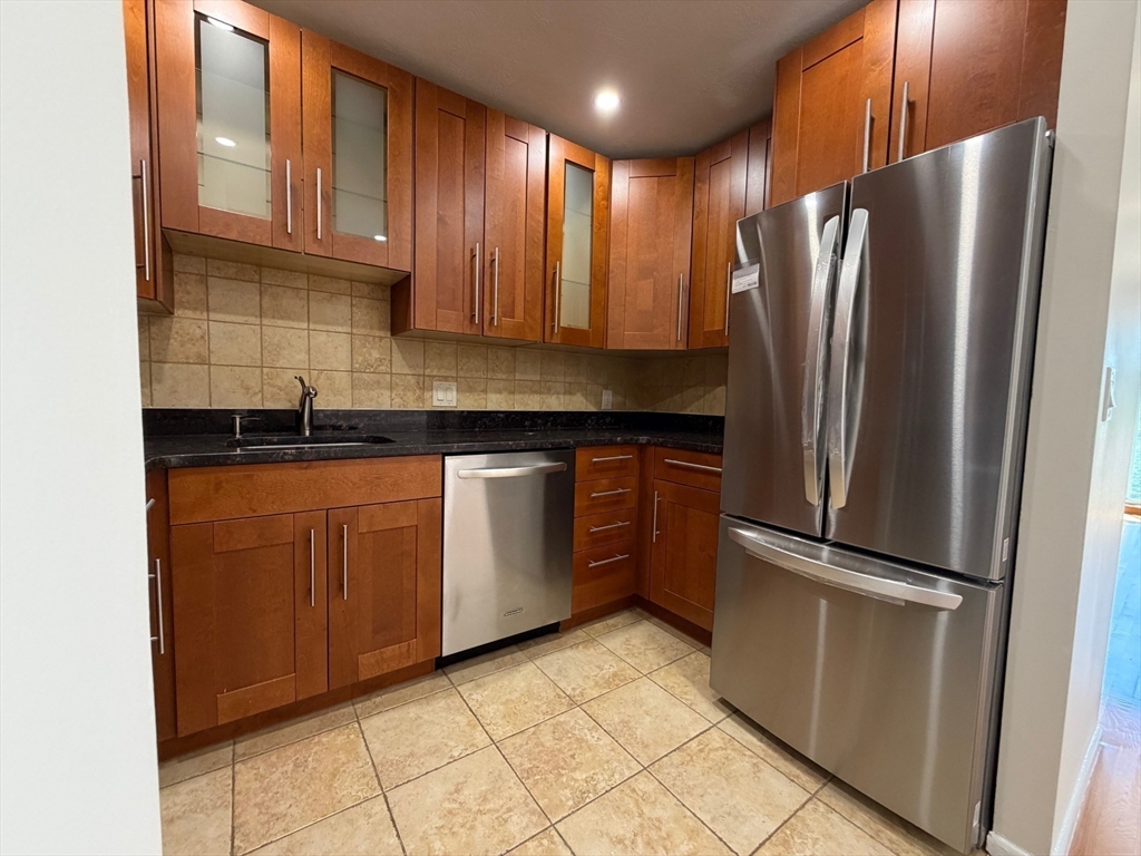 383 Langley Road, Unit 11 Newton, MA 02459 - Photo 4 of 15 a kitchen with stainless steel appliances granite countertop a refrigerator and a sink