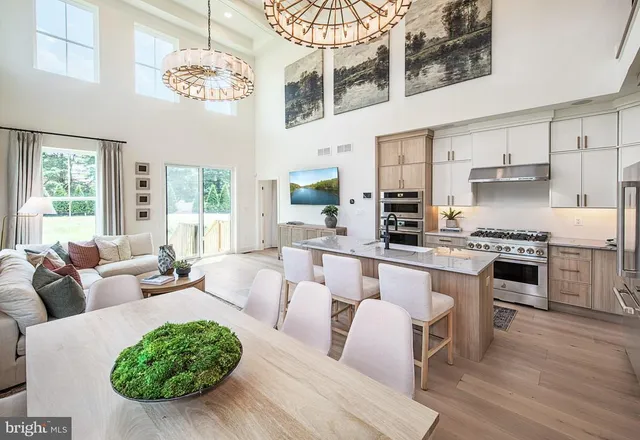 a living room with furniture kitchen and a chandelier