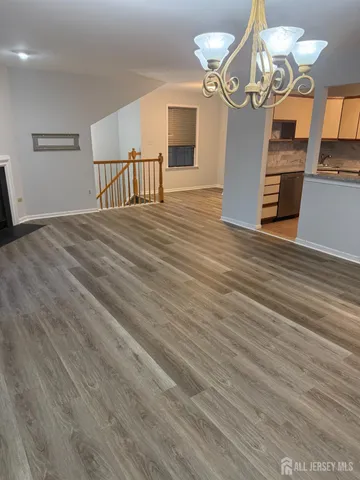 a view of a livingroom with a chandelier furniture and wooden floor