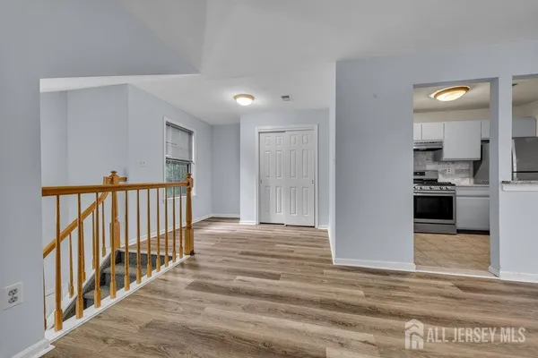 a view of a hallway with wooden floor and dining room