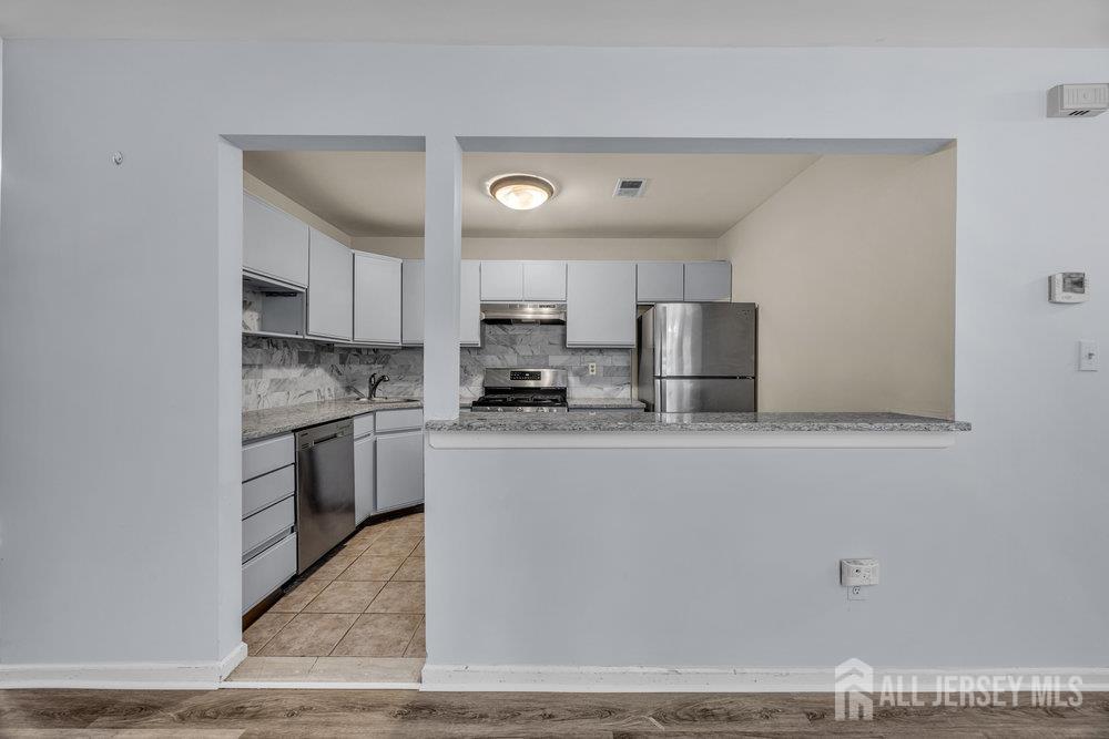 604 Woodhaven Drive Edison, NJ 08817 - Photo 12 of 38 a kitchen with stainless steel appliances granite countertop a stove a sink and a refrigerator