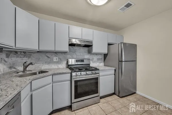 a kitchen with a stove sink and refrigerator