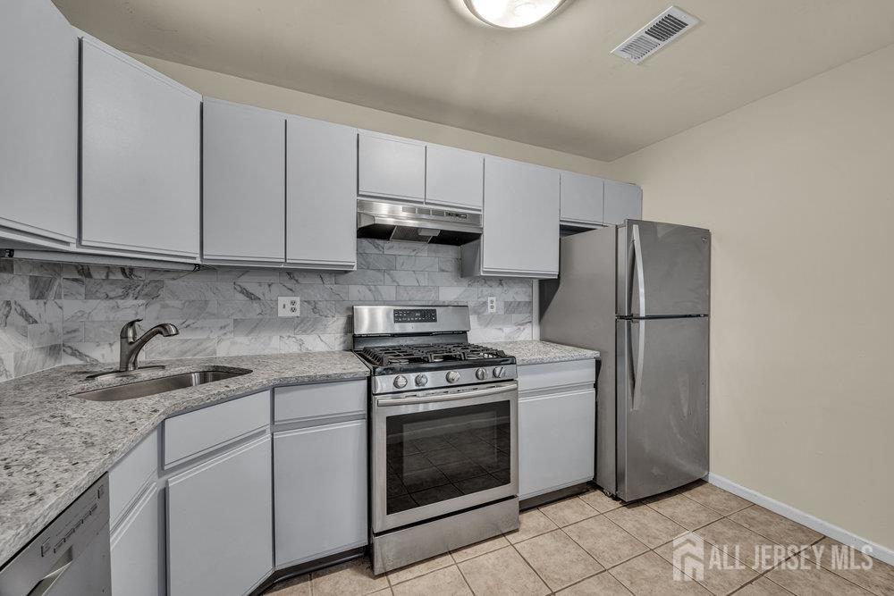 604 Woodhaven Drive Edison, NJ 08817 - Photo 13 of 38 a kitchen with a stove sink and refrigerator