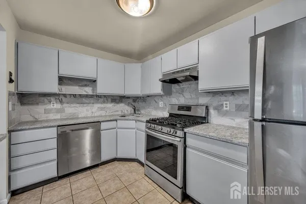 a kitchen with cabinets stainless steel appliances and a counter space