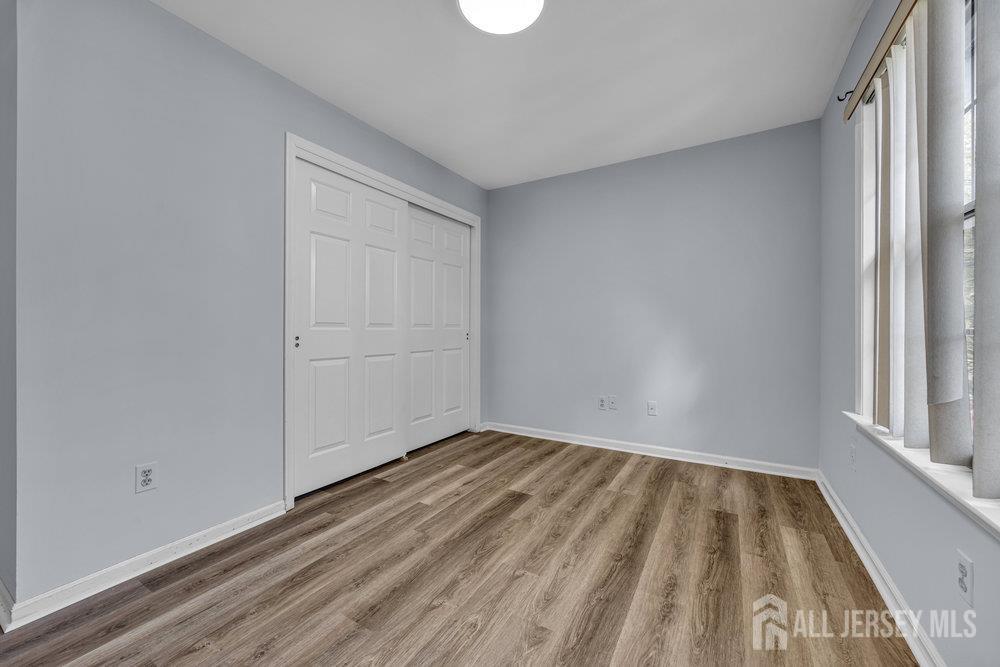 604 Woodhaven Drive Edison, NJ 08817 - Photo 19 of 38 a view of empty room with wooden floor and fan