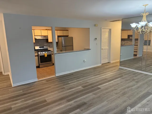 a view of a kitchen with wooden floor and a refrigerator