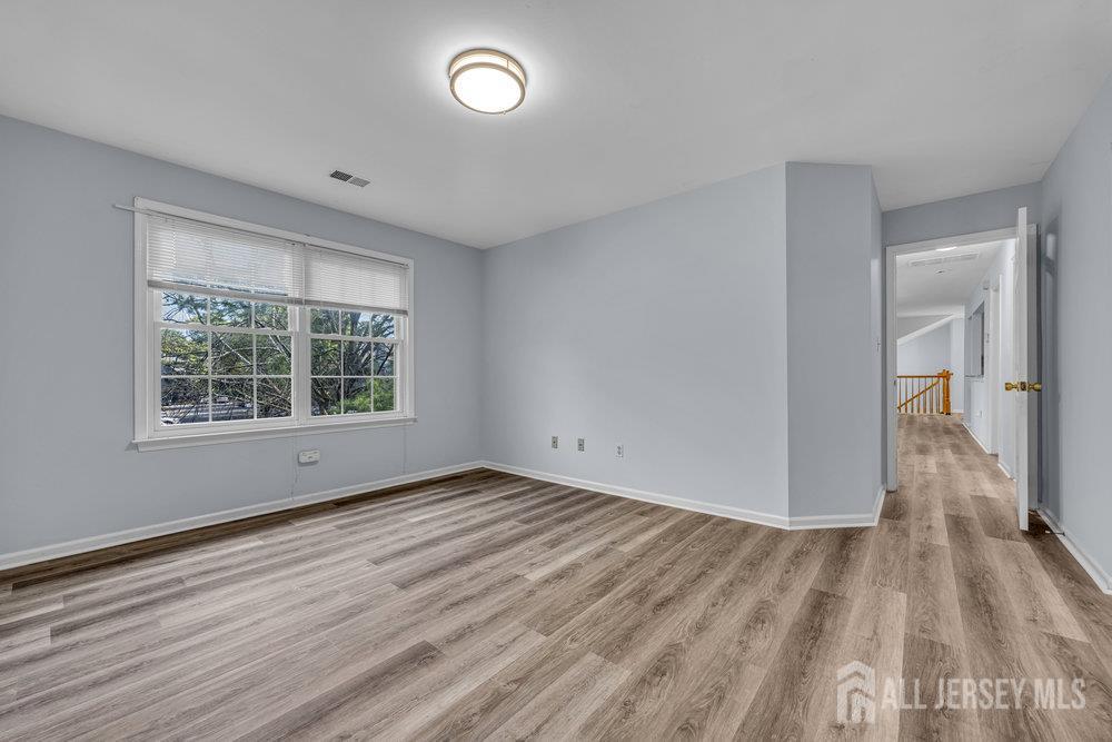 604 Woodhaven Drive Edison, NJ 08817 - Photo 22 of 38 a view of an empty room with wooden floor and a window