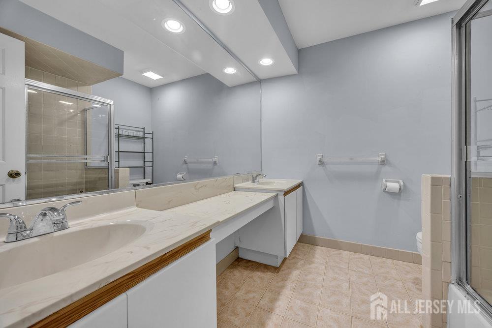 604 Woodhaven Drive Edison, NJ 08817 - Photo 25 of 38 a bathroom with a sink and a mirror