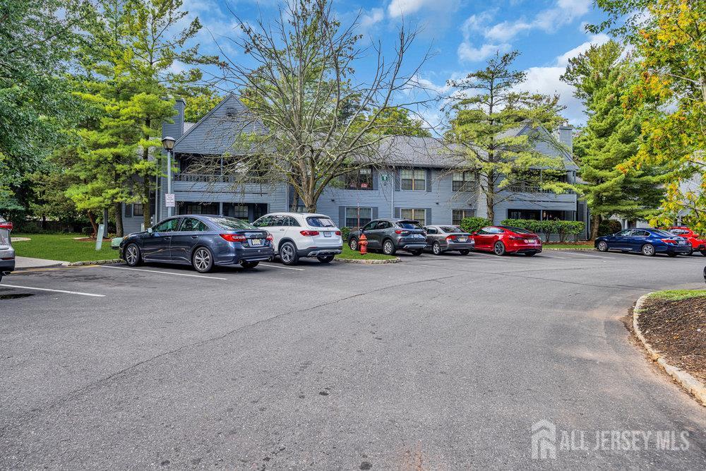 604 Woodhaven Drive Edison, NJ 08817 - Photo 3 of 38 a view of road with card parked on side and retail shops