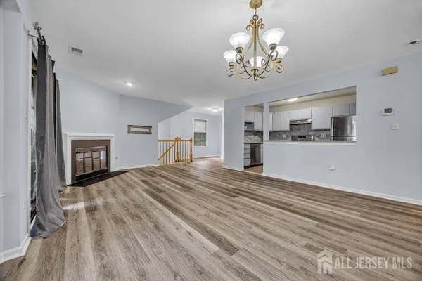 a view of a livingroom with a furniture wooden floor and a kitchen