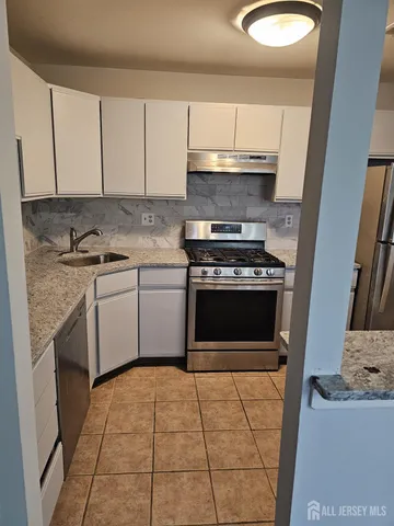 a kitchen with a stove sink and cabinets