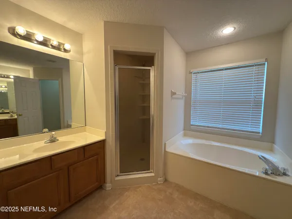 a bathroom with a tub a sink and a mirror