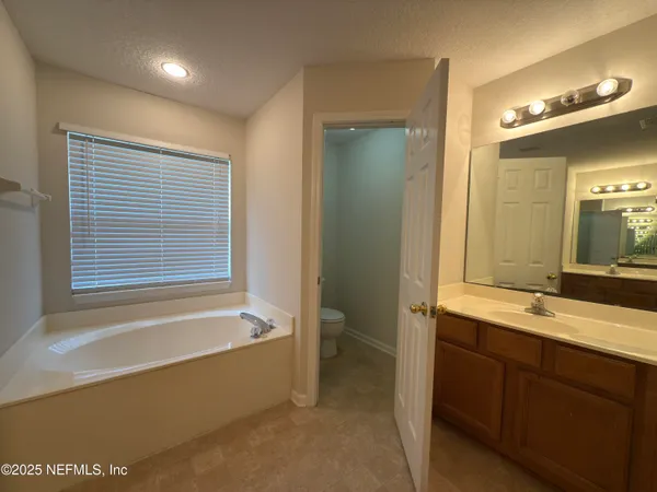 a bathroom with a tub sink and mirror
