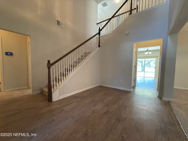a view of a hallway with wooden floor and stairs