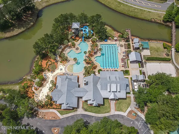 an aerial view of a house with a garden and lake view